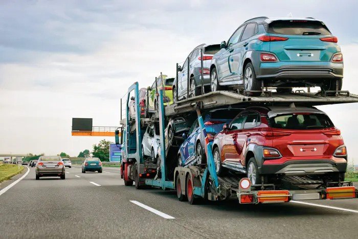 "Car Shipping New York - open car carrier hauling multiple SUVs on highway"