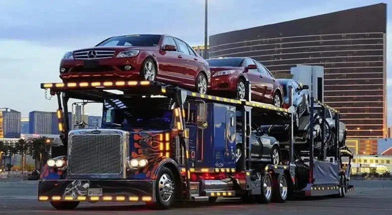 illuminated car carrier truck loaded with sedans - Car Shipping Texas service