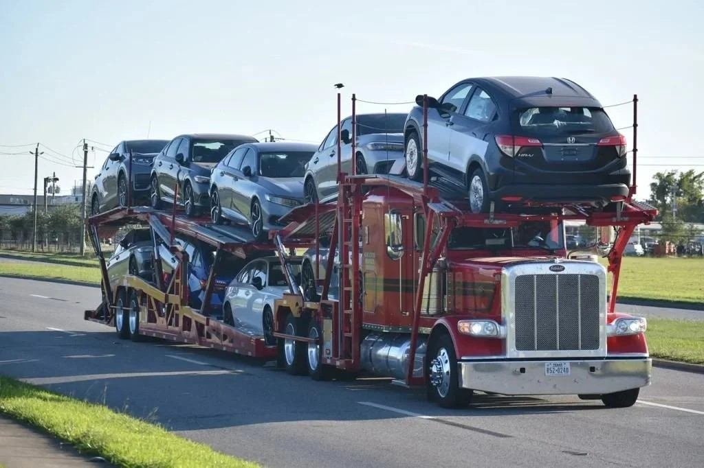 "Car Shipping Florida - open car carrier hauling multiple vehicles on highway"